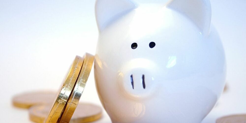 Stacked coins against a piggy bank