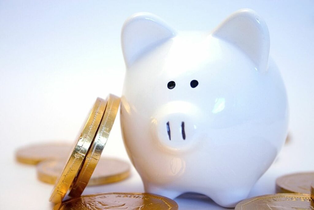 Stacked coins against a piggy bank