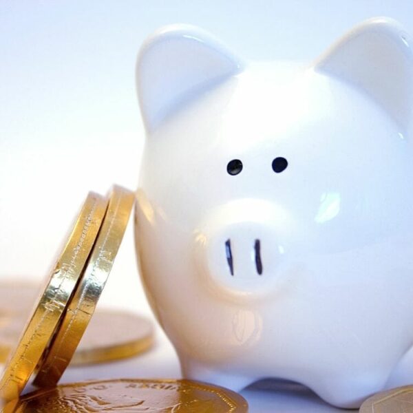 Stacked coins against a piggy bank