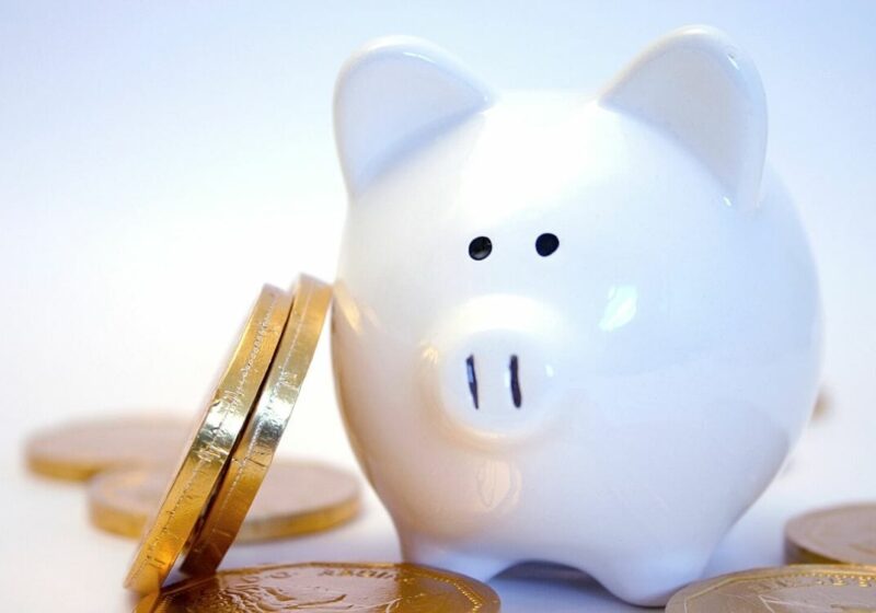 Stacked coins against a piggy bank