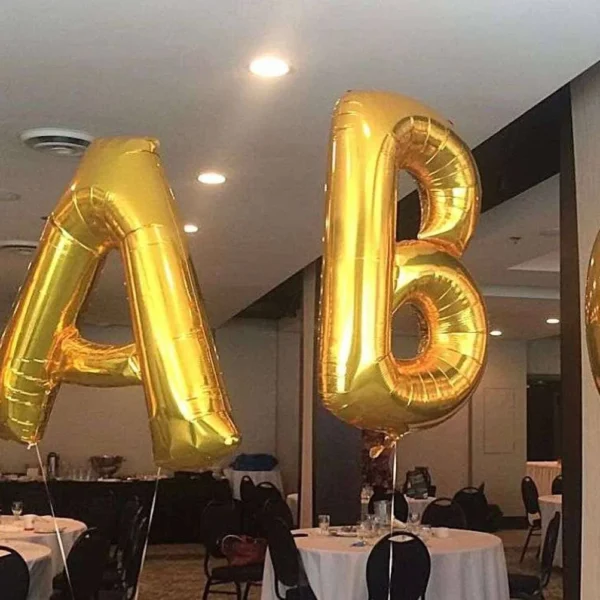 Golden helium balloon letters "IABC" floating in a conference room with set tables, suggesting an event or celebration related to the International Association of Business Communicators.