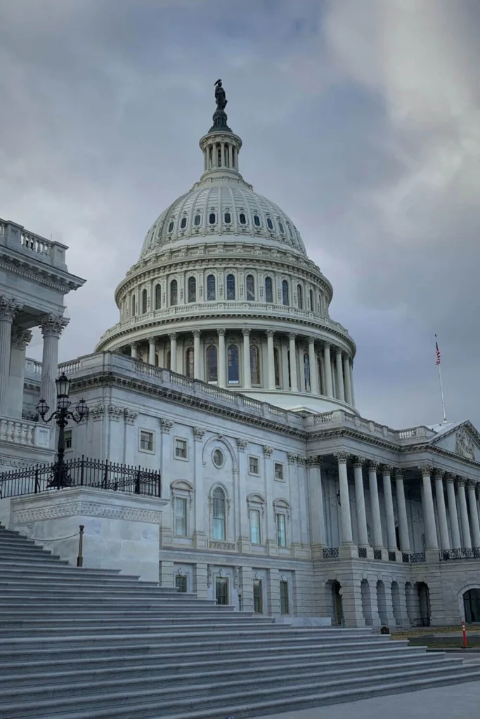 Dramatic close-up of the U.S. Capitol dome in Washington DC, capturing the seat of American government and its fragile role in protecting or eroding democracy under authoritarian threats.