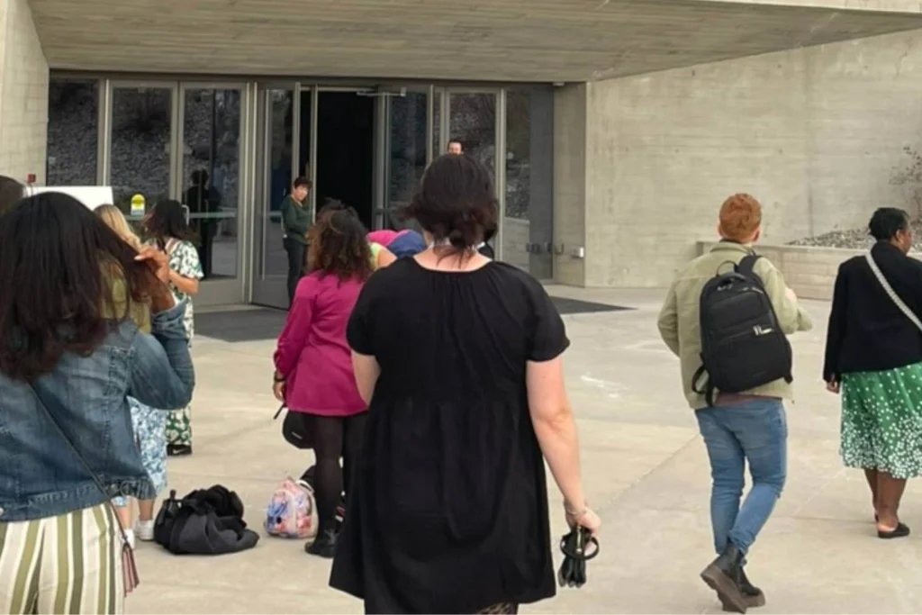Diverse group of women entering a modern venue, representing community, education, and activism through ethical travel events.
