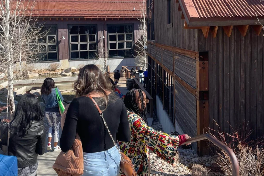 Group of diverse women exploring a rustic outdoor venue together, representing community, intentional travel, and shared experiences.