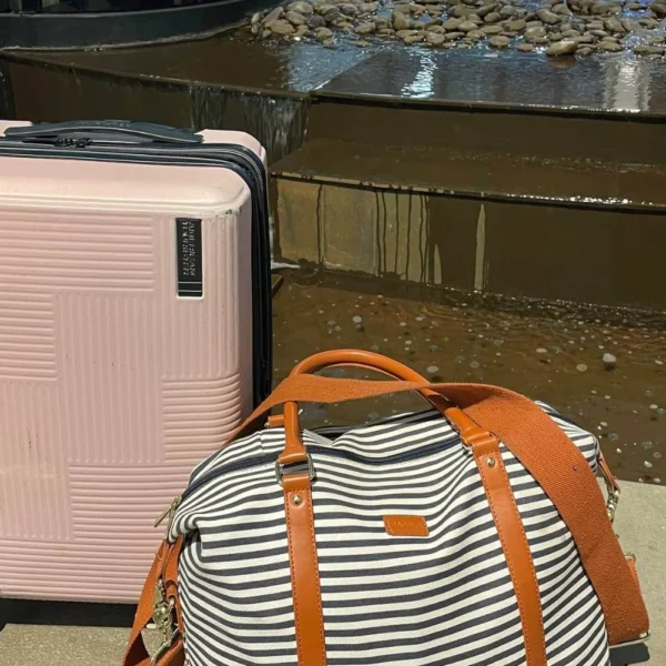 Pink suitcase and striped weekender bag packed for Calgary Stampede solo travel trip