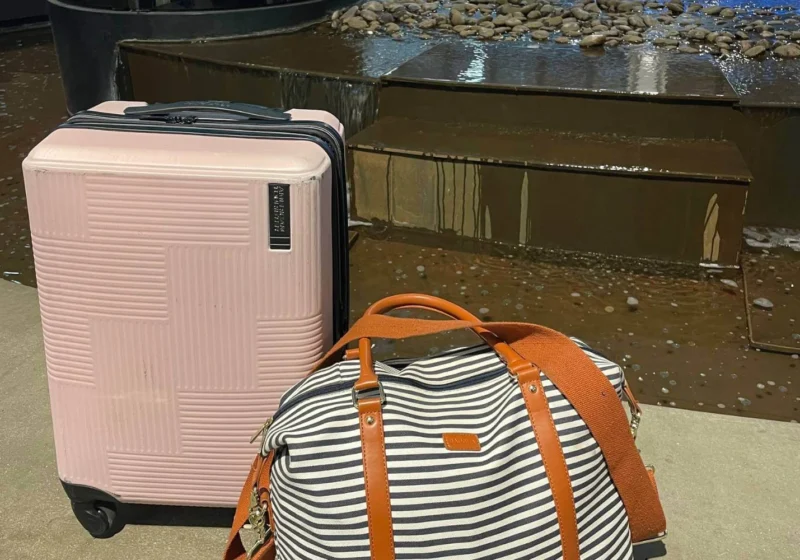 Pink suitcase and striped weekender bag packed for Calgary Stampede solo travel trip