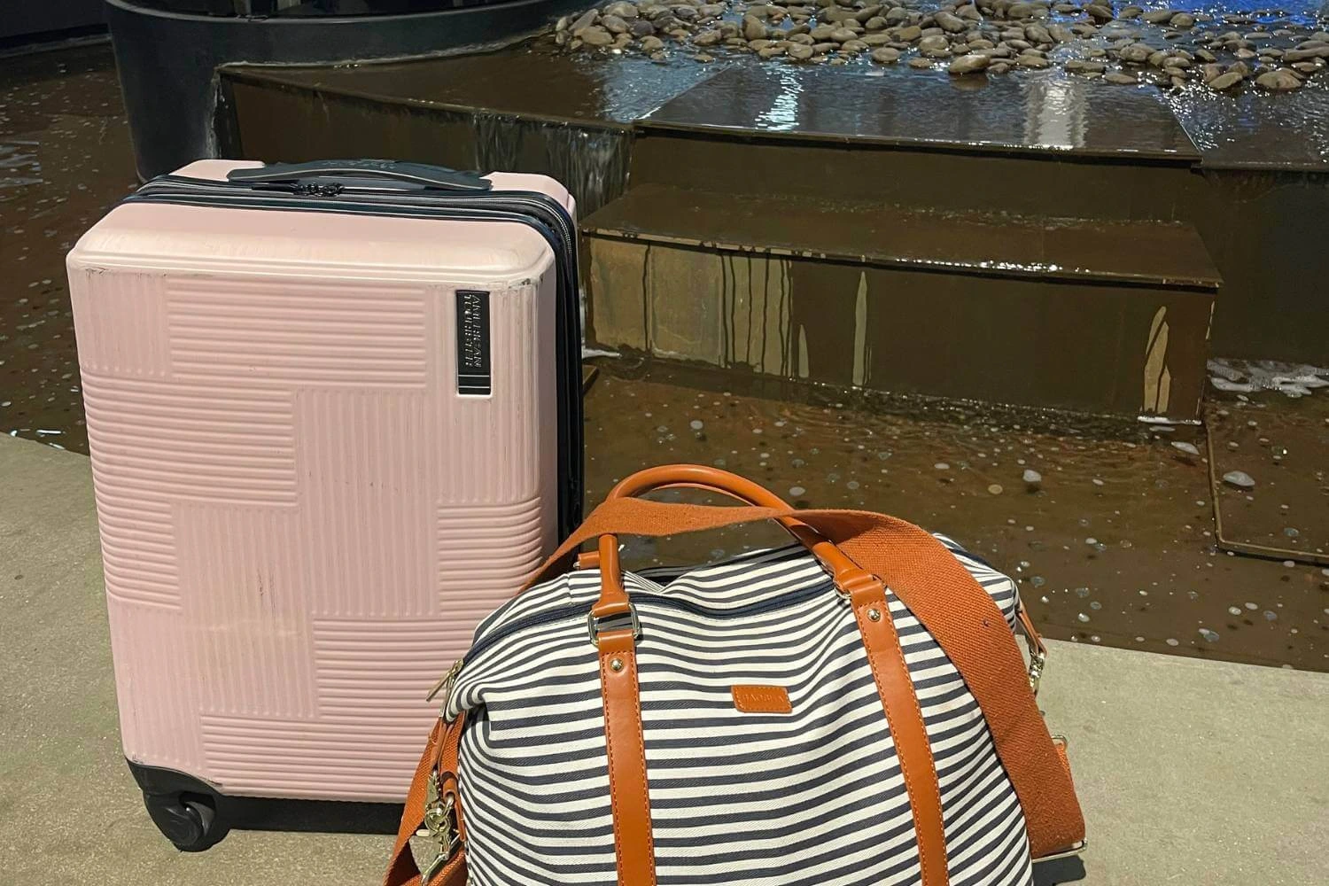 Pink suitcase and striped weekender bag packed for Calgary Stampede solo travel trip