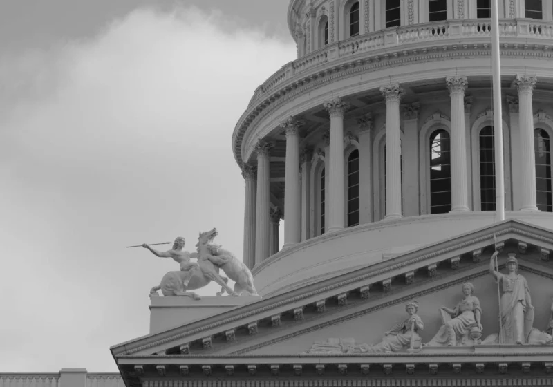 Close-up of the U.S. Capitol dome with classical warrior statue, evoking the aggressive symbolism often tied to authoritarian power structures.