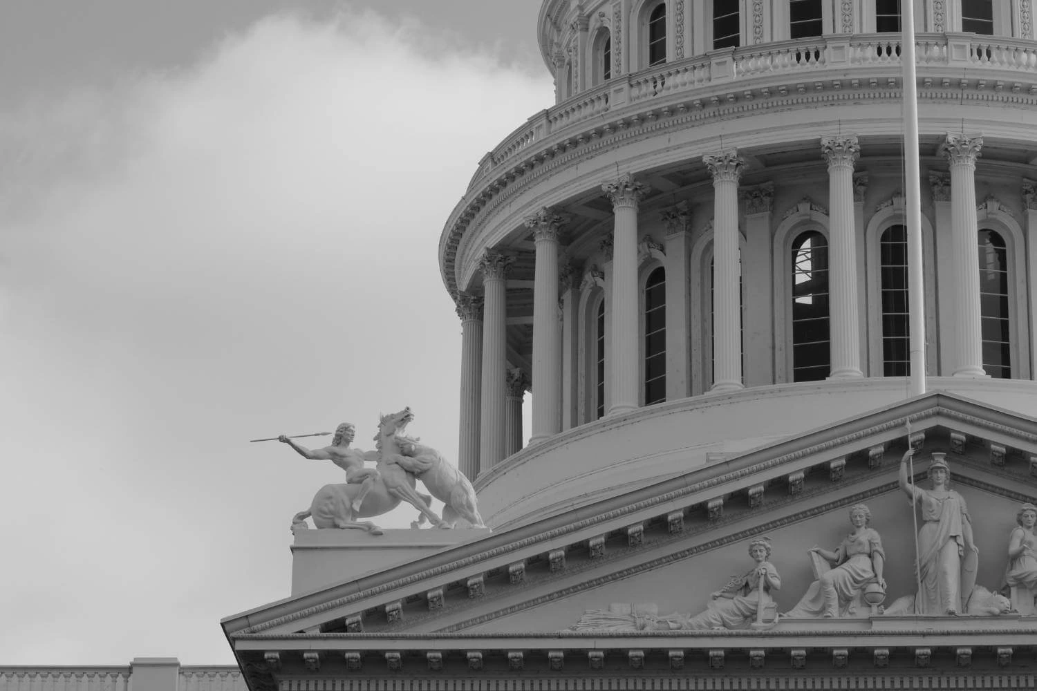 Close-up of the U.S. Capitol dome with classical warrior statue, evoking the aggressive symbolism often tied to authoritarian power structures.