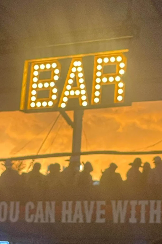 BAR sign glowing above crowd silhouettes at Cowboys Music Festival in Calgary.