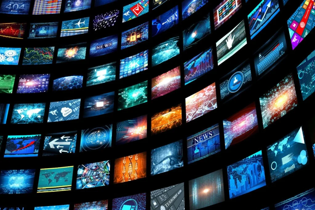 Multiple television screens displaying news broadcasts, symbolizing global media networks and information overload.
