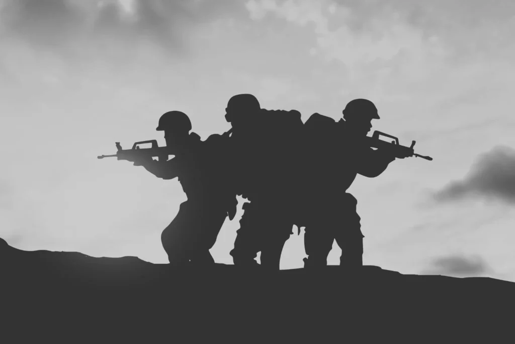 Silhouette of three armed soldiers standing alert on a battlefield at dawn, representing how authoritarian regimes turn militaries into instruments of control and violence.