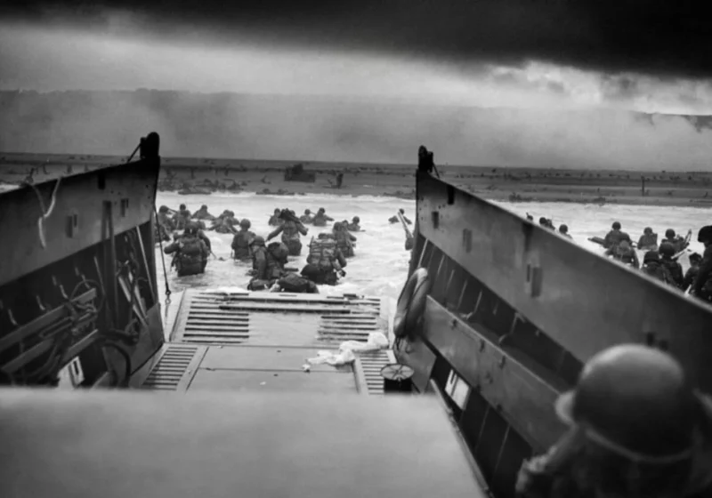 Allied soldiers wading ashore during the D-Day invasion highlighting the antifascist fight against Nazi Germany.