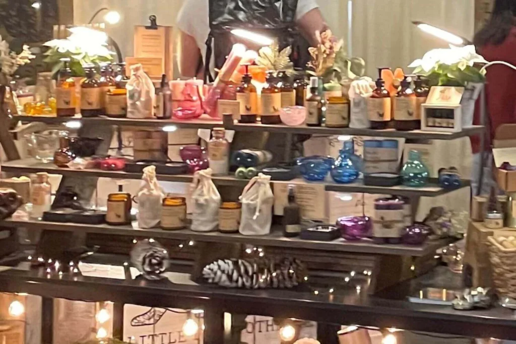 Holiday artisan market display featuring handmade candles, oils, and festive small gifts.