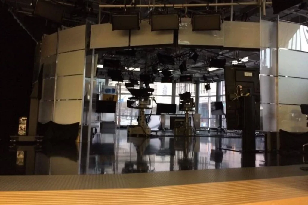 Modern television news studio in Vancouver with broadcast cameras and bright overhead lighting before going live.