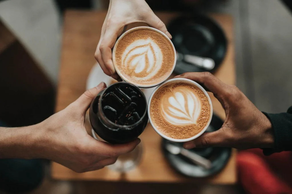 Solo travellers reconnecting over coffee during a cozy catch-up, symbolising travel friendships and shared memories.