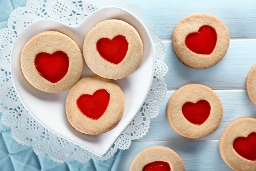 Traditional British jam heart biscuits arranged on a plate, a classic festive Christmas treat.