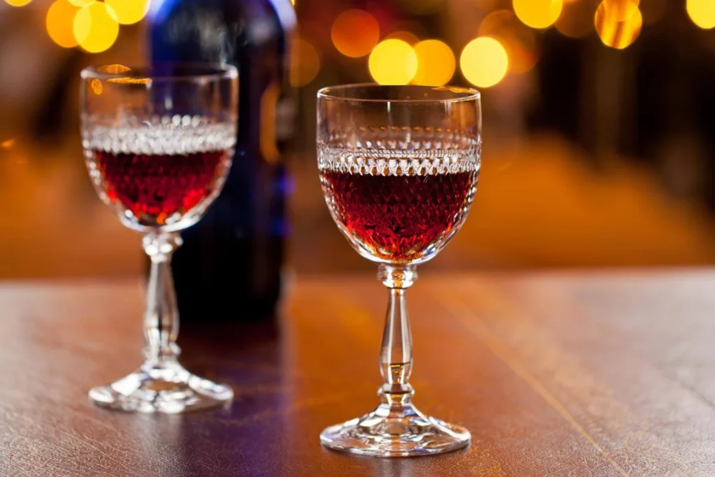 Two glasses of sherry served as a traditional British Christmas after-dinner drink with festive lights in the background.