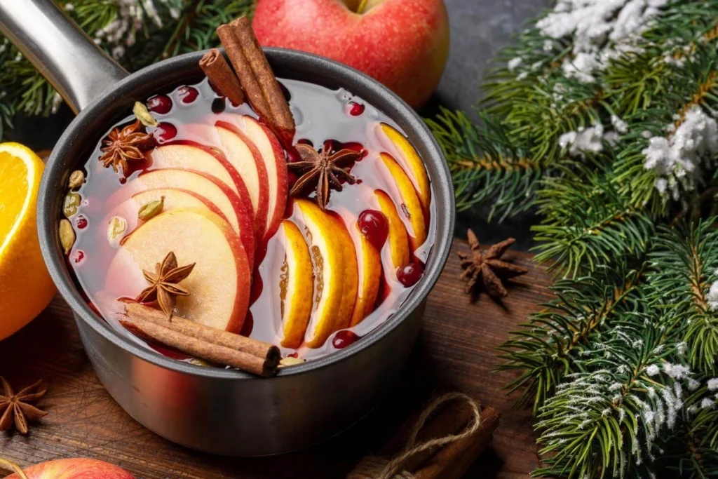 Saucepan of British mulled wine with cinnamon, citrus slices, and warming spices.
