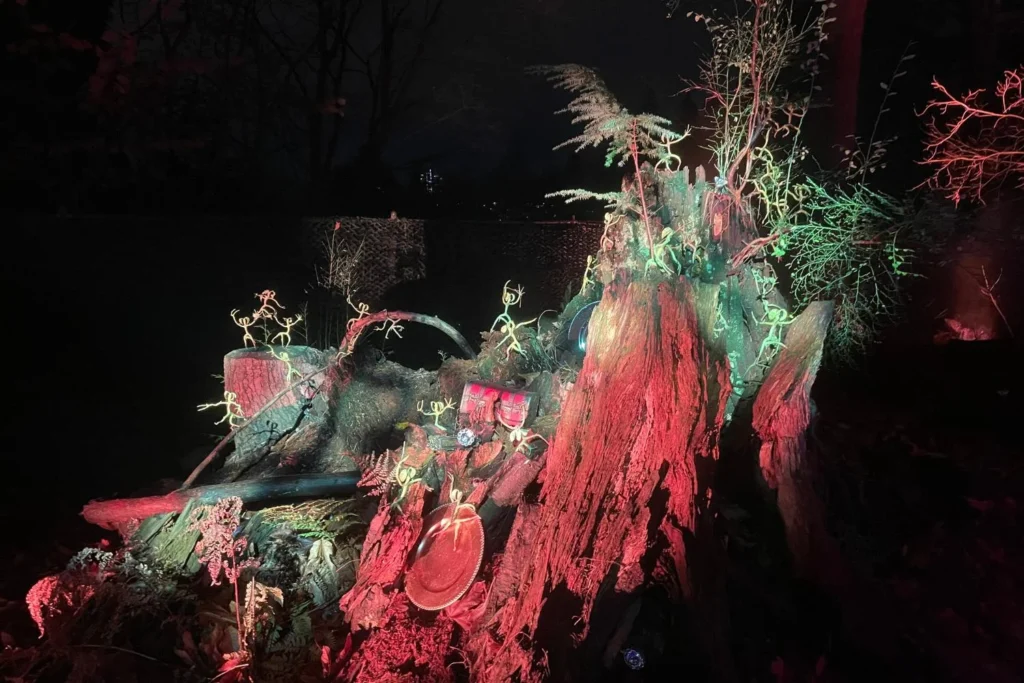 A forest stump decorated with glowing Bowtruckle creatures and magical props at the Harry Potter Forbidden Forest Experience.