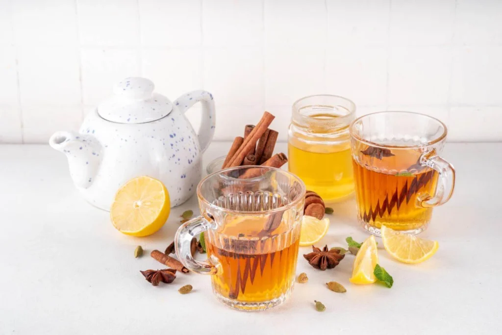 Ingredients for making a traditional British hot toddy with whisky, honey, lemon, and spices.