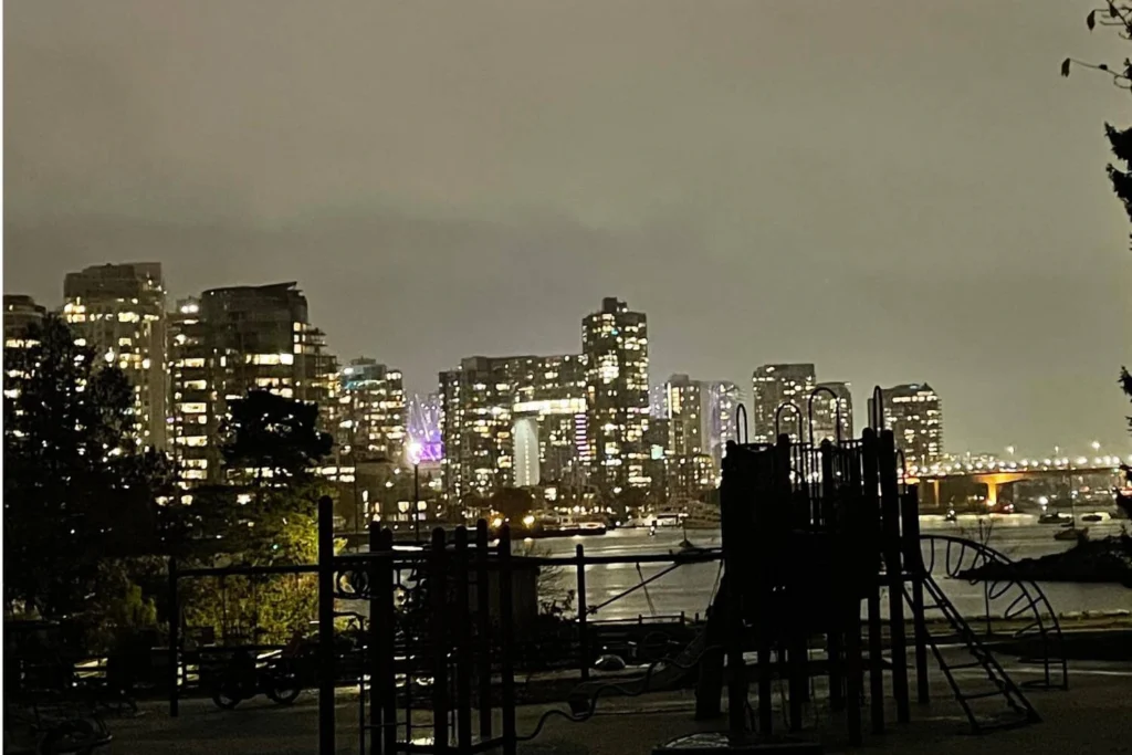 Vancouver skyline at night in winter with cloudy skies and city lights reflecting on the water