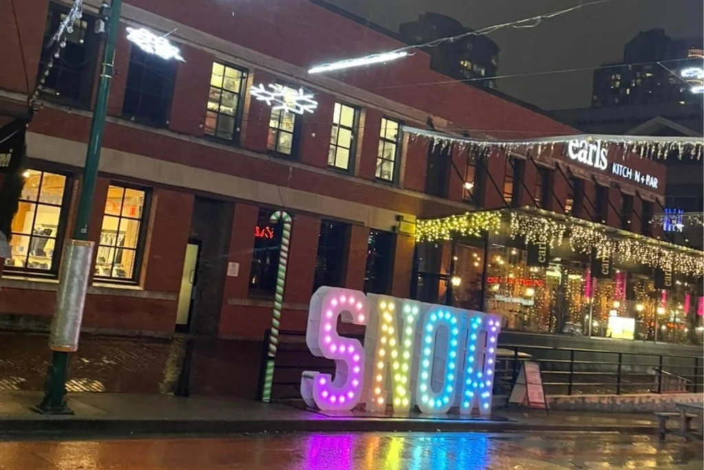 Christmas lights and festive signage in Yaletown, Vancouver on a rainy winter evening.