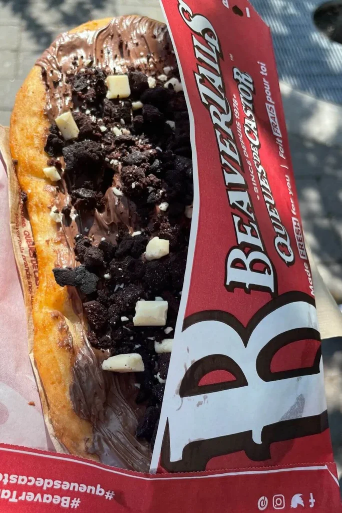 BeaverTails pastry topped with chocolate and cookie pieces, a popular Canadian winter treat.
