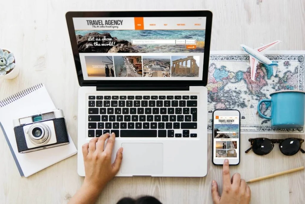 Solo traveler researching and booking travel online using a laptop and smartphone.