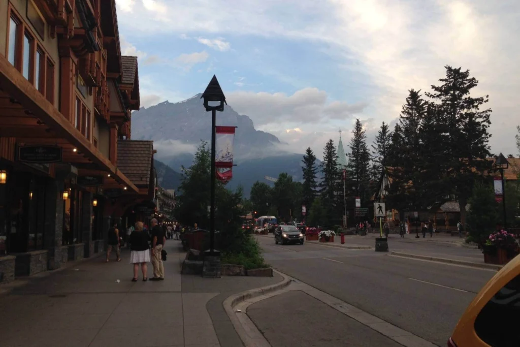 Mountain town street in Banff, Canada with shops and mountain views, showing cultural experiences alongside nature for solo travelers.