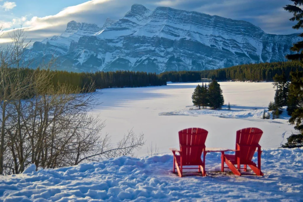 Peaceful winter landscape in Canada with snow-covered lake and mountains, reflecting the calm side of solo travel in winter.