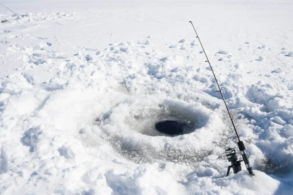 Ice fishing on a frozen lake in Canada during winter, a traditional cold-weather activity popular across Canadian provinces.