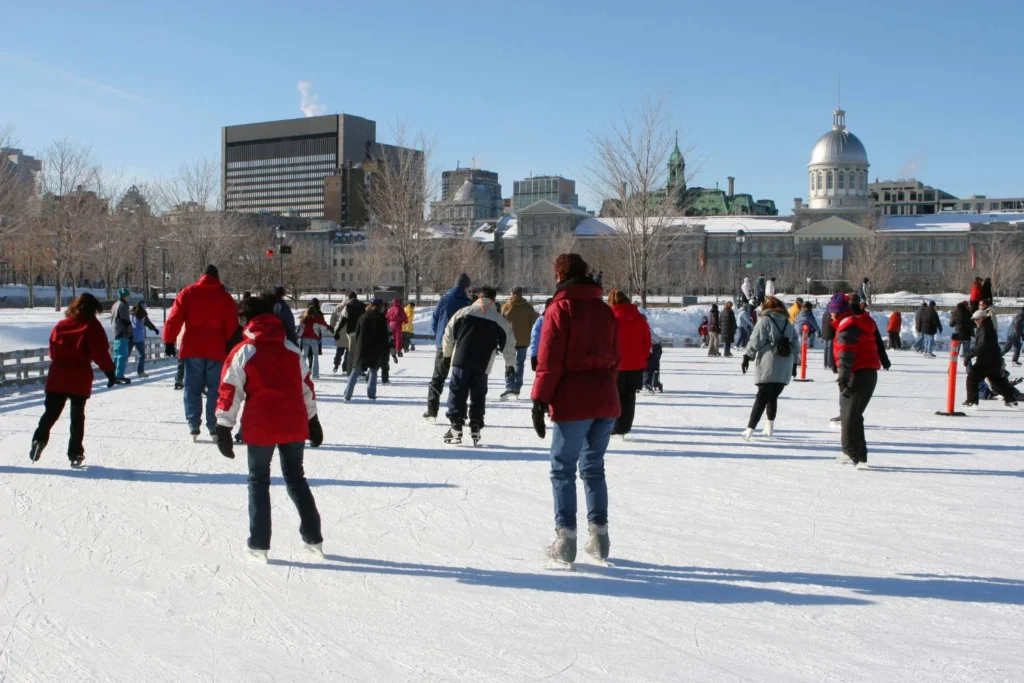 People ice skating outdoors in a Canadian city during winter, a popular seasonal activity in places like Montreal.