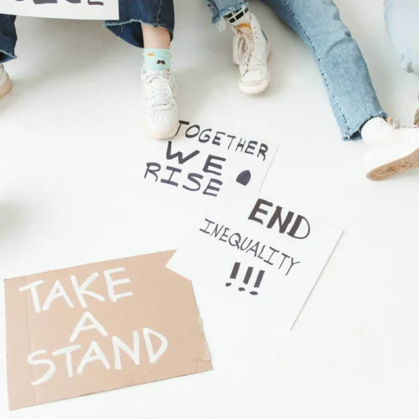 Megaphone and protest signs on the ground with messages about inequality and taking a stand.