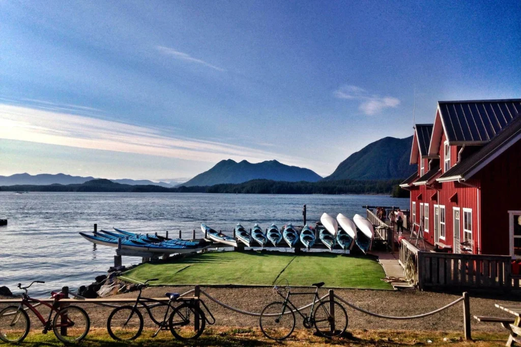 Tofino on Vancouver Island with kayaks by the water and mountains in the background, a peaceful coastal destination for solo travelers in Canada.
