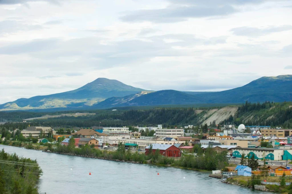 Whitehorse town along the Yukon River surrounded by mountains, a remote yet welcoming solo travel destination in northern Canada.