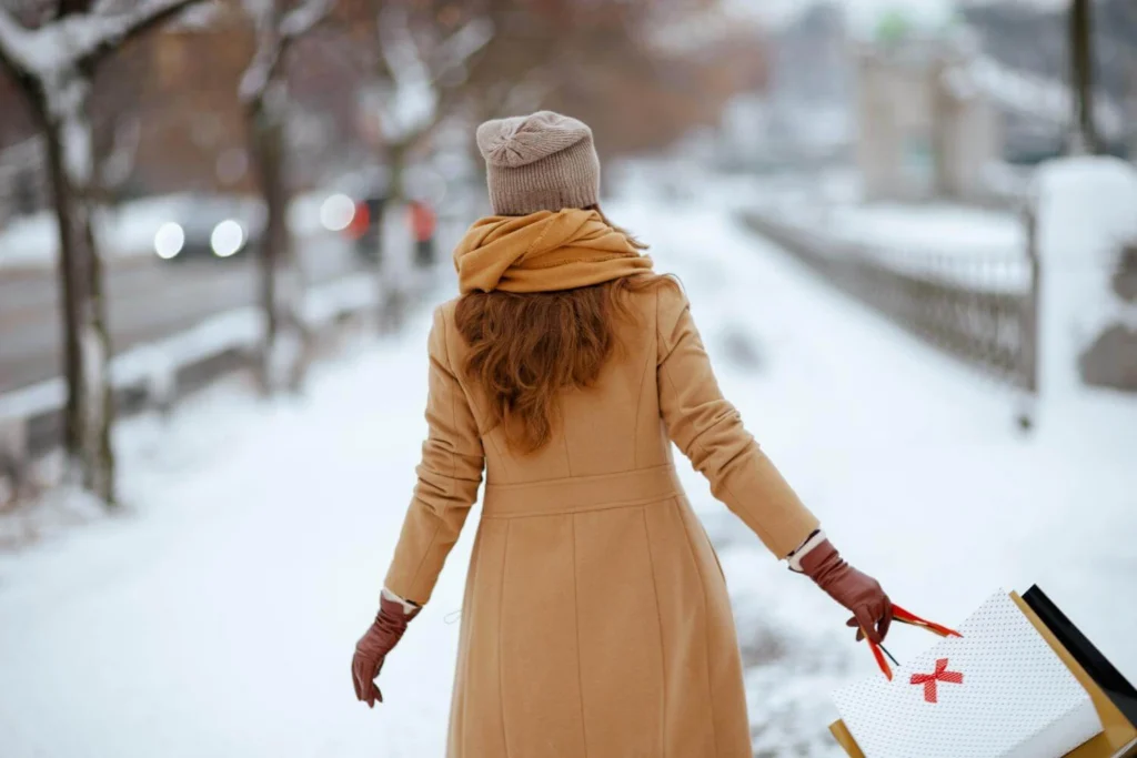 Solo traveler walking through a snowy city street in winter, moving forward calmly and independently.